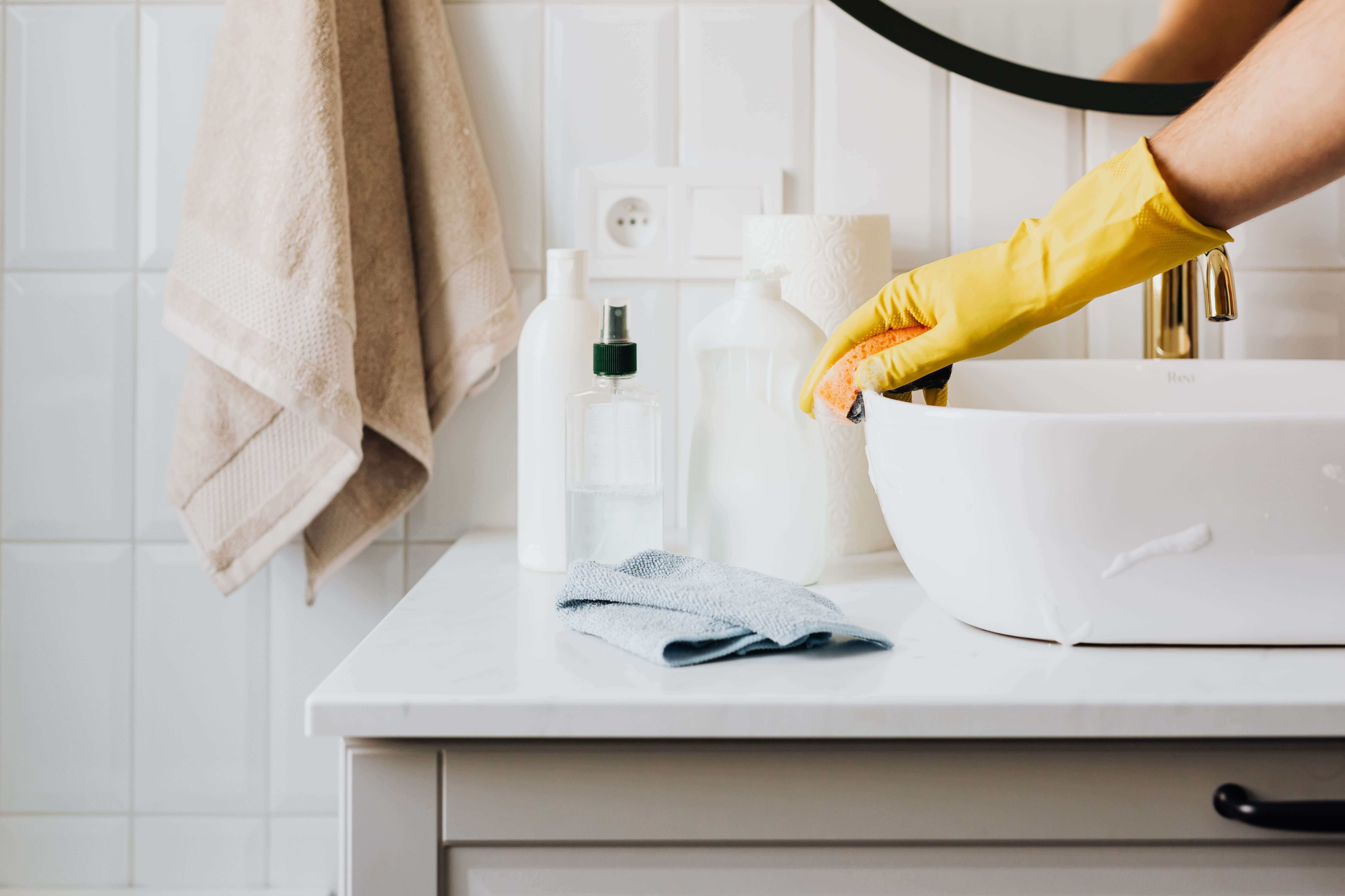Sibella Cleaning technician wiping down a countertop in a bright, freshly cleaned Utah home